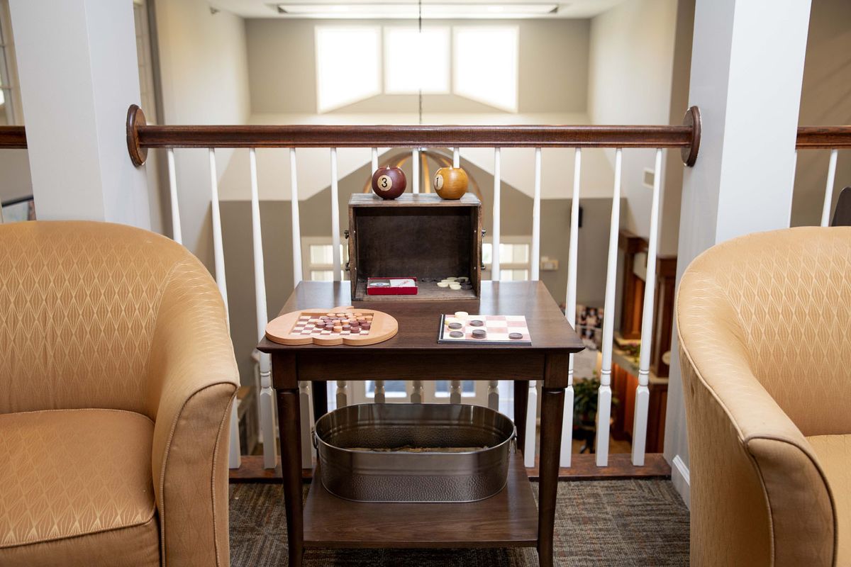 A cozy living area featuring a small wooden table adorned with decorative items, placed between two chairs.
