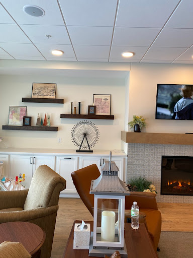 A cozy, modern living room featuring stylish furniture, decorative shelves, and a warm fireplace.