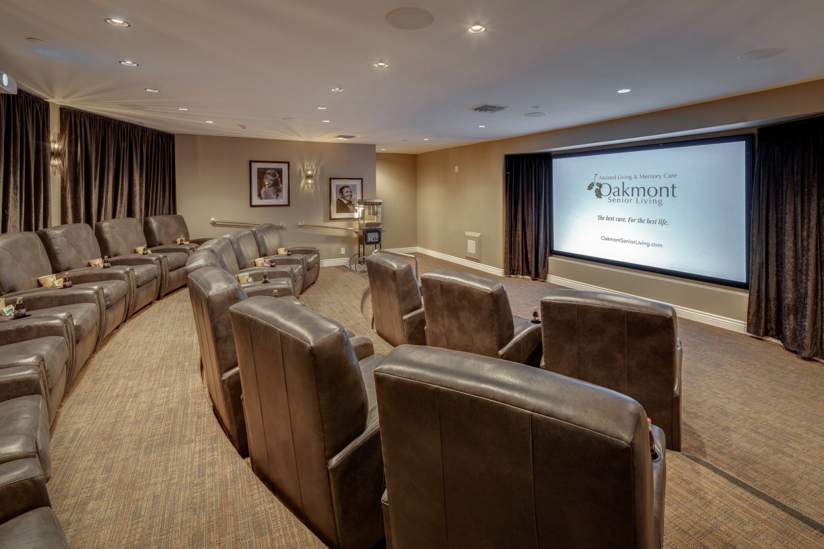 A cozy home theater room with recliner seating and a large projector screen.