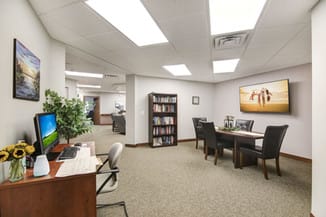 A professional office space with desks, chairs, and a bookshelf.