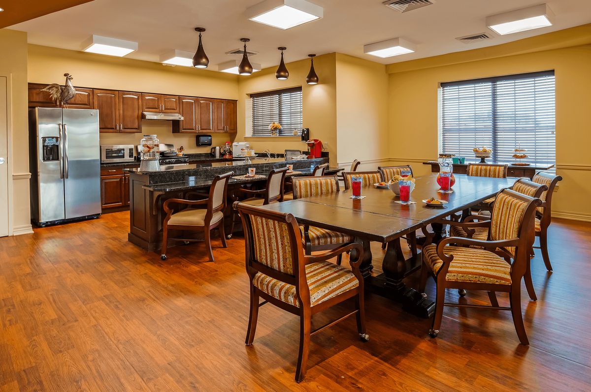 A cozy kitchen and dining area with wooden floors and ample seating.