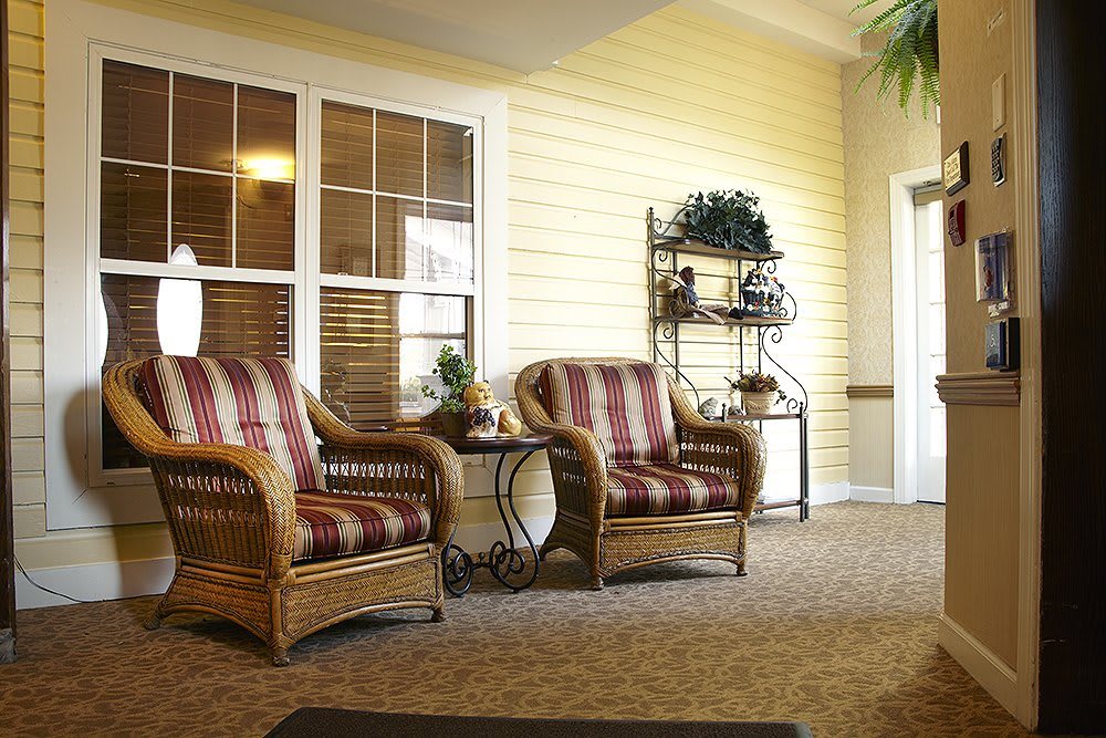A cozy sitting area with wicker chairs and decorative shelving.