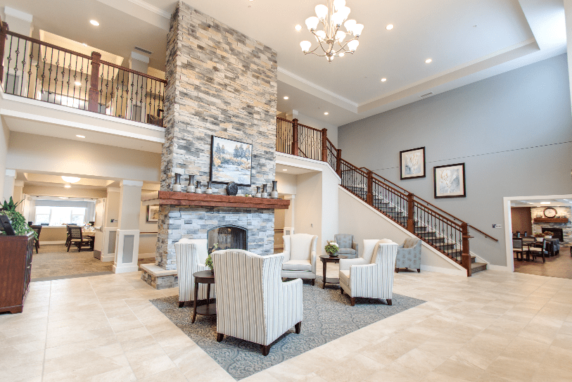 A luxurious lobby featuring a stone fireplace, elegant chandelier, and modern seating area.