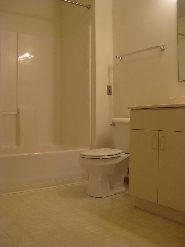 A clean and simple bathroom with a bathtub, toilet, and sink.
