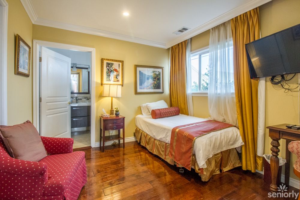 A cozy bedroom with a single bed, warm lighting, and elegant decor.