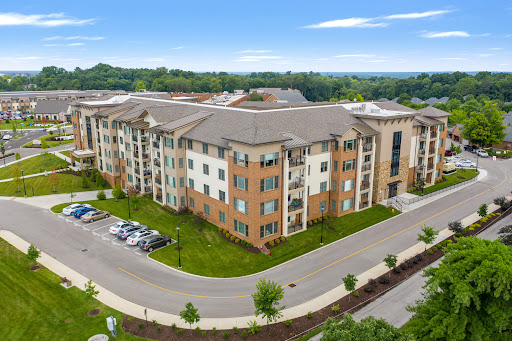 Aerial view of a modern residential apartment complex surrounded by greenery.