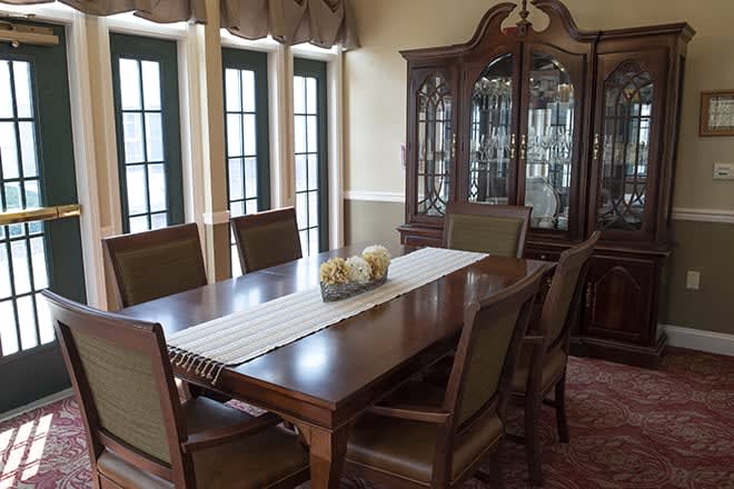 Elegant dining room with a large wooden table, chairs, and a china cabinet.