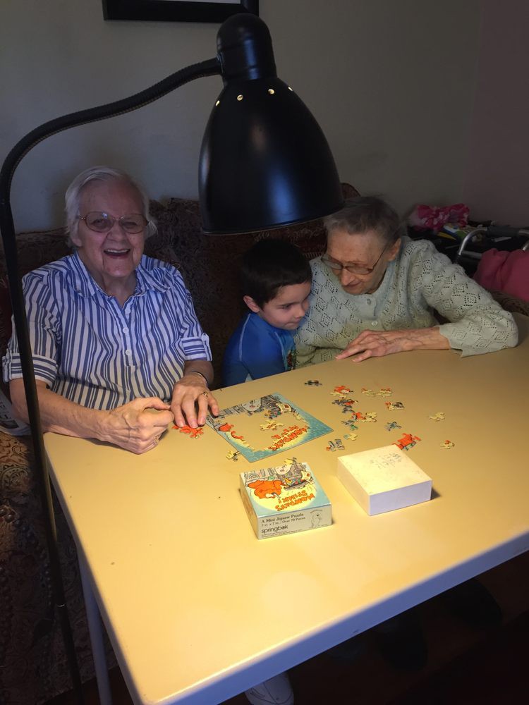 A family enjoys a puzzle together, highlighting the joy of intergenerational bonding.