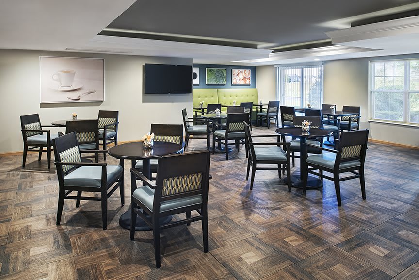An empty indoor restaurant dining area with neatly arranged tables and chairs.