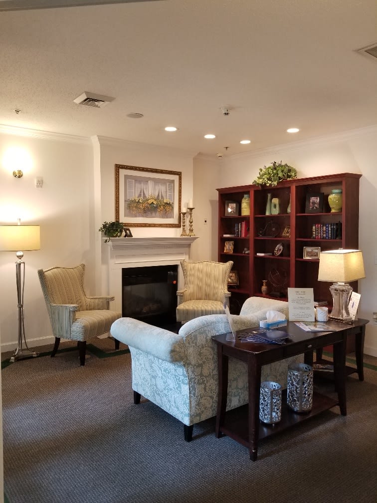 A cozy living room with a fireplace, comfortable seating, and a well-stocked bookshelf.