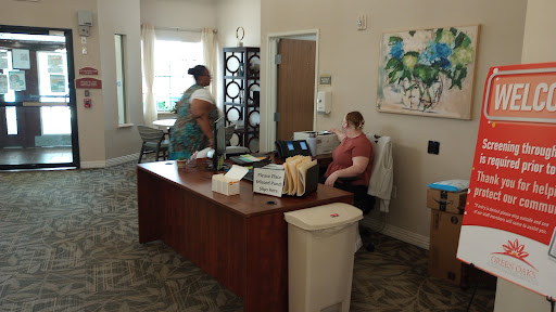 A cozy office space featuring a reception desk with two individuals engaged in conversation.