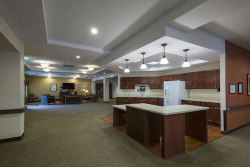 A spacious and modern kitchen area featuring an open layout with wooden cabinetry and contemporary lighting.