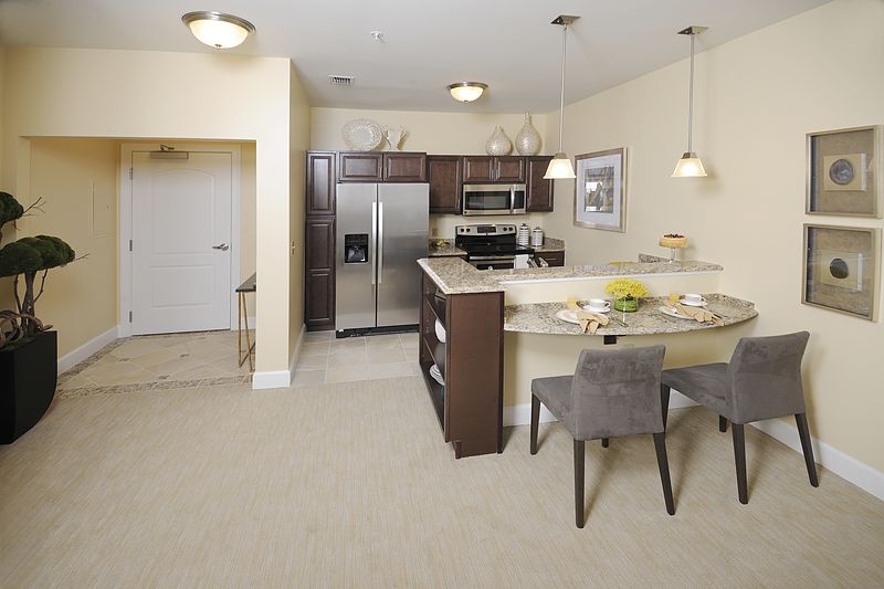 A modern kitchen with stainless steel appliances and a cozy seating area.