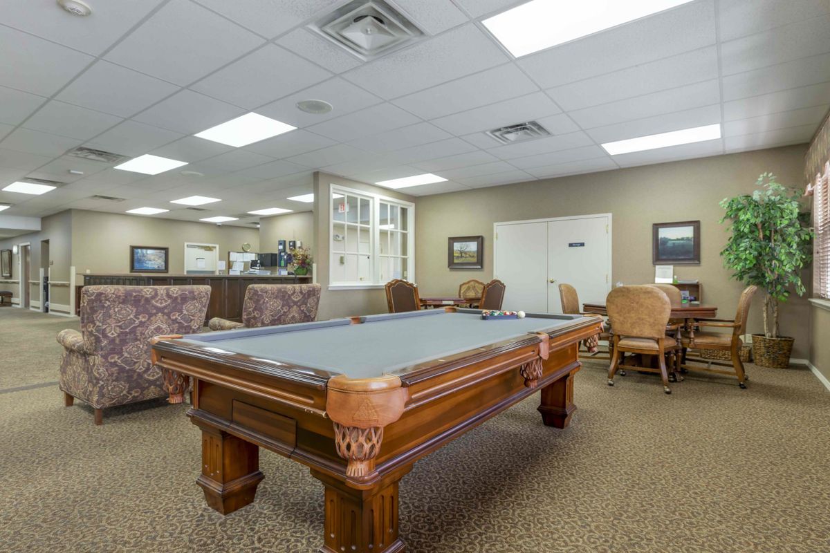 A spacious recreation room featuring a pool table and comfortable seating.