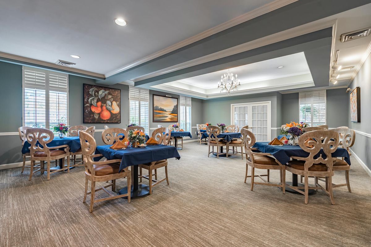 A stylish dining room with elegantly set tables and decorative art on the walls.