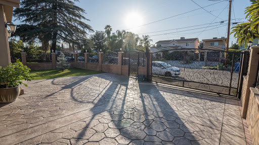 A serene view of a sunny day showcasing the shadows cast by a gate in a residential area.