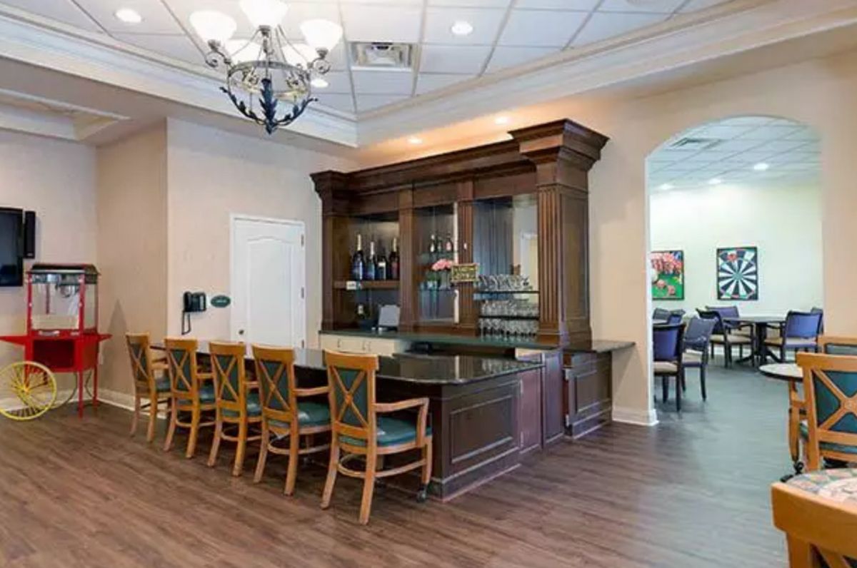 A well-furnished bar area with wooden chairs and a classic chandelier.