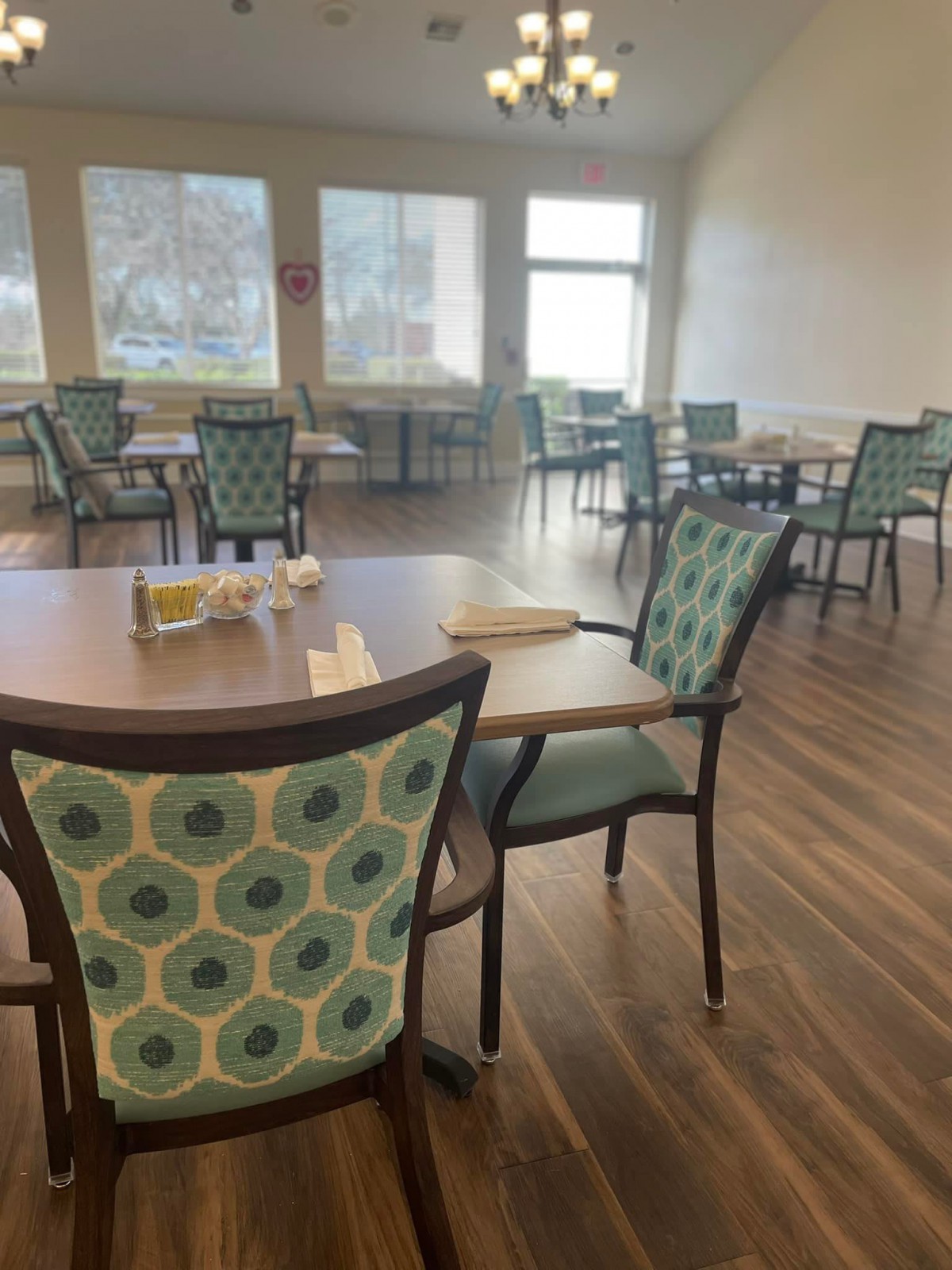 An empty dining room with neatly arranged tables and chairs.