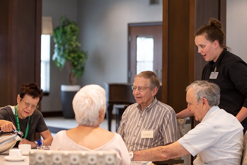 A group of seniors engaged in conversation at a community center.