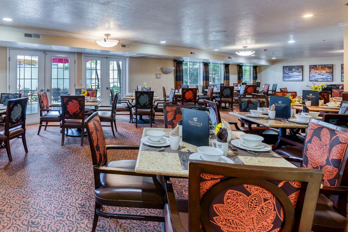A well-set dining area with elegantly arranged tables and chairs, ready for guests.