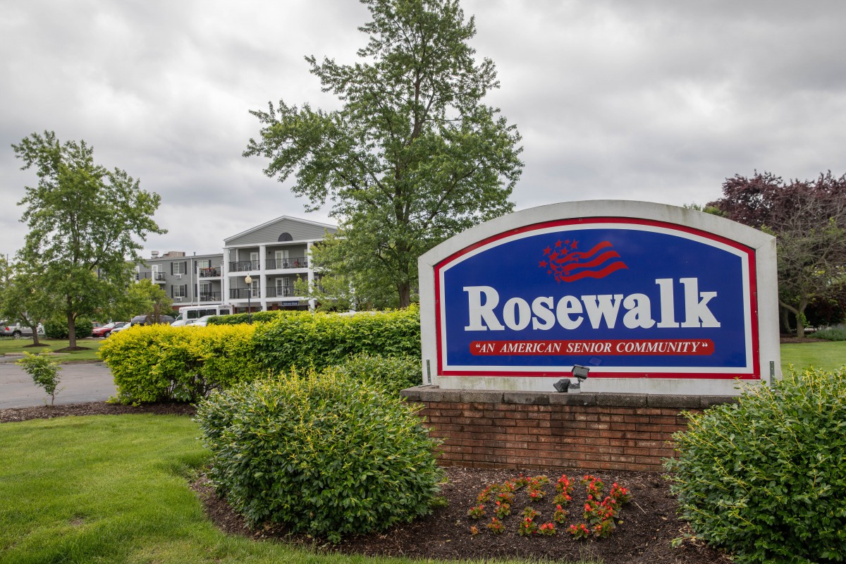 Entrance sign of the Rosewall retirement community with landscaped greenery and residential buildings in the background.