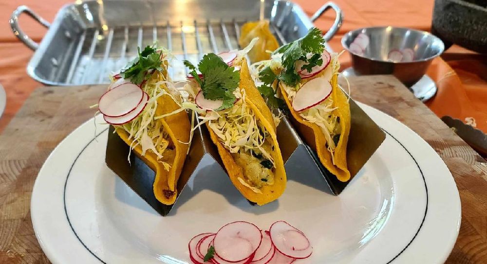 Three delicious tacos filled with fresh ingredients and topped with radishes and cilantro.