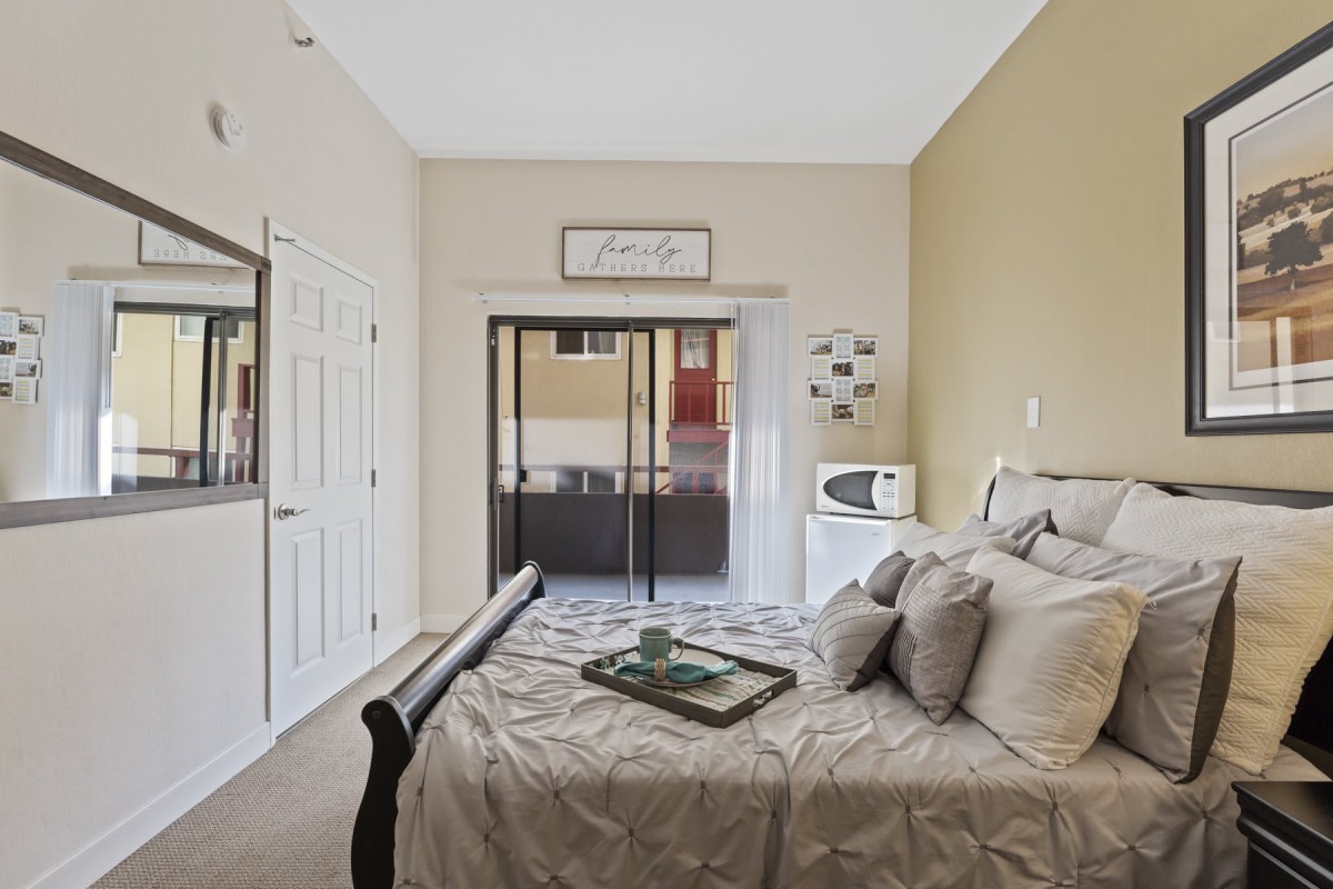 A cozy bedroom with elegant decor and sliding doors leading to another room.