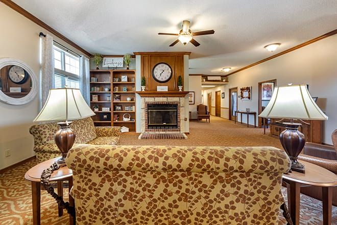 A cozy living room with a central fireplace, bookshelves, and comfortable seating.