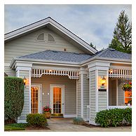 A well-lit, inviting house entrance with a porch and decorative columns.