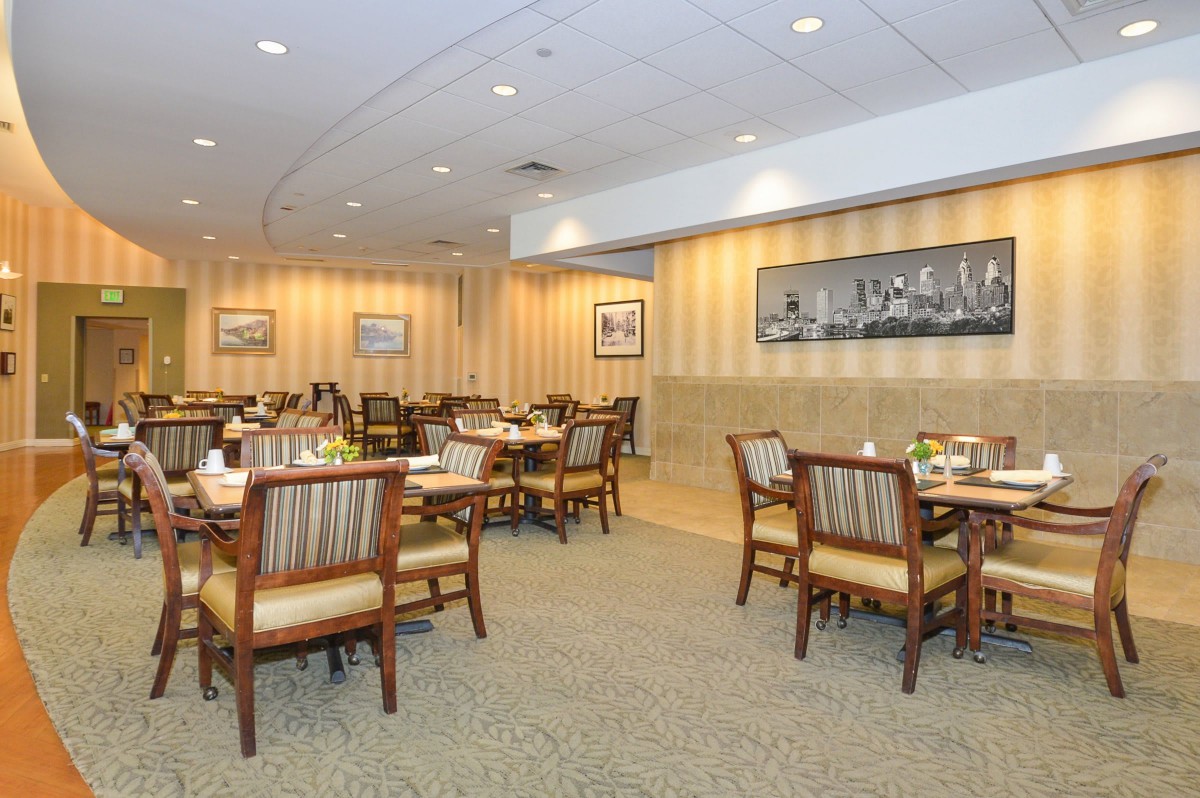 An empty restaurant dining area with neatly arranged tables and chairs.
