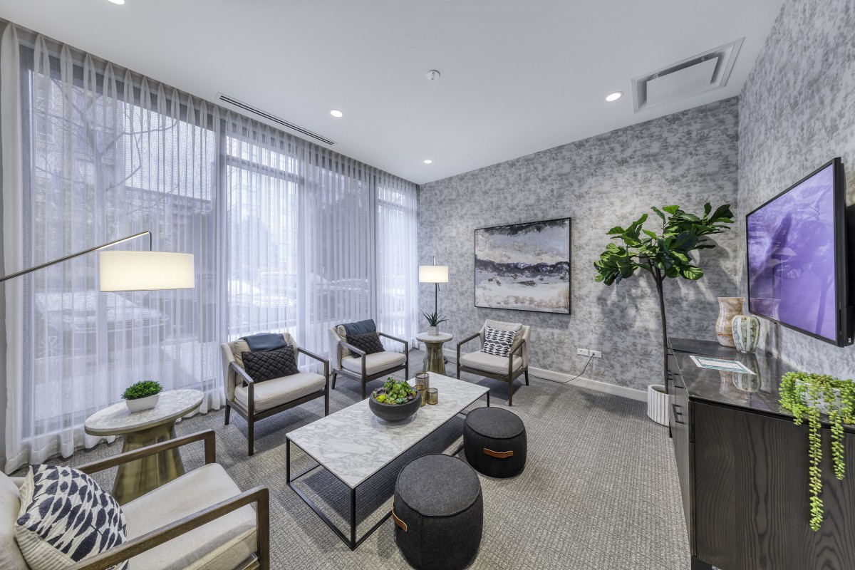 A modern and elegantly designed living room with comfortable seating, stylish decor, and abundant natural light.