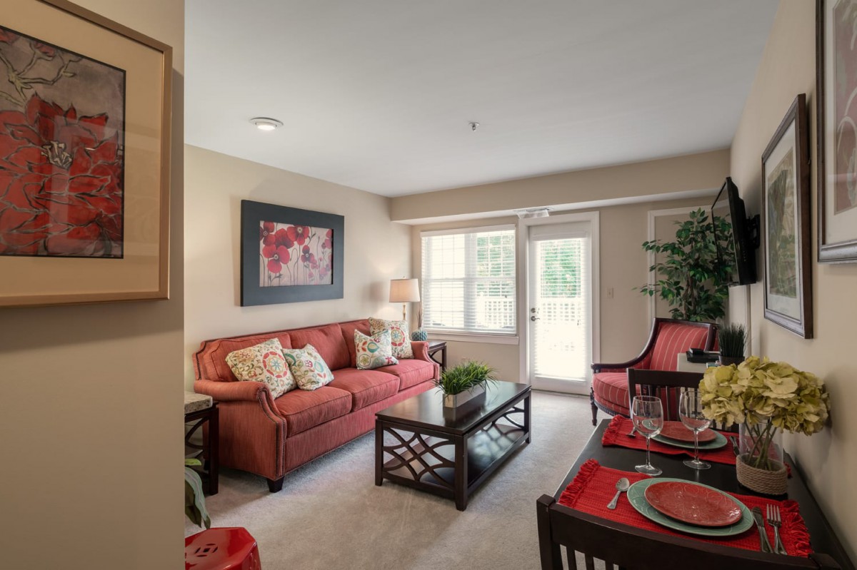 A cozy living room featuring a red sofa, coffee table, and decorative elements.