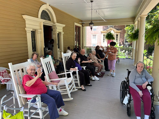 Residents enjoy a sunny day on the porch, sharing moments and smiles.