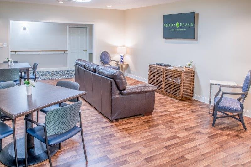 A cozy living room with a sofa, television, and hardwood floor.