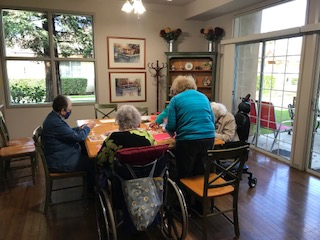 A group of elderly individuals engaging in an activity in a nursing home setting.