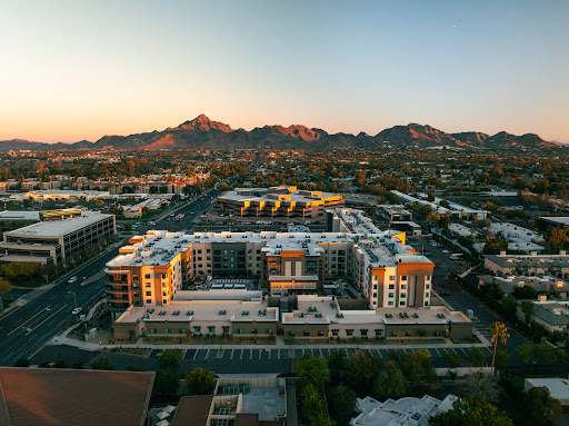 A stunning aerial view of modern residential buildings surrounded by mountains at sunset.
