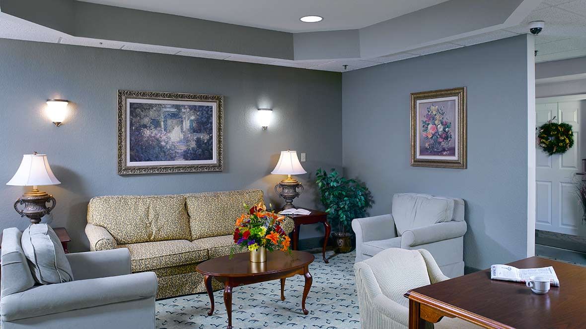 A cozy living room with sofas, chairs, a coffee table, and artwork on the walls.