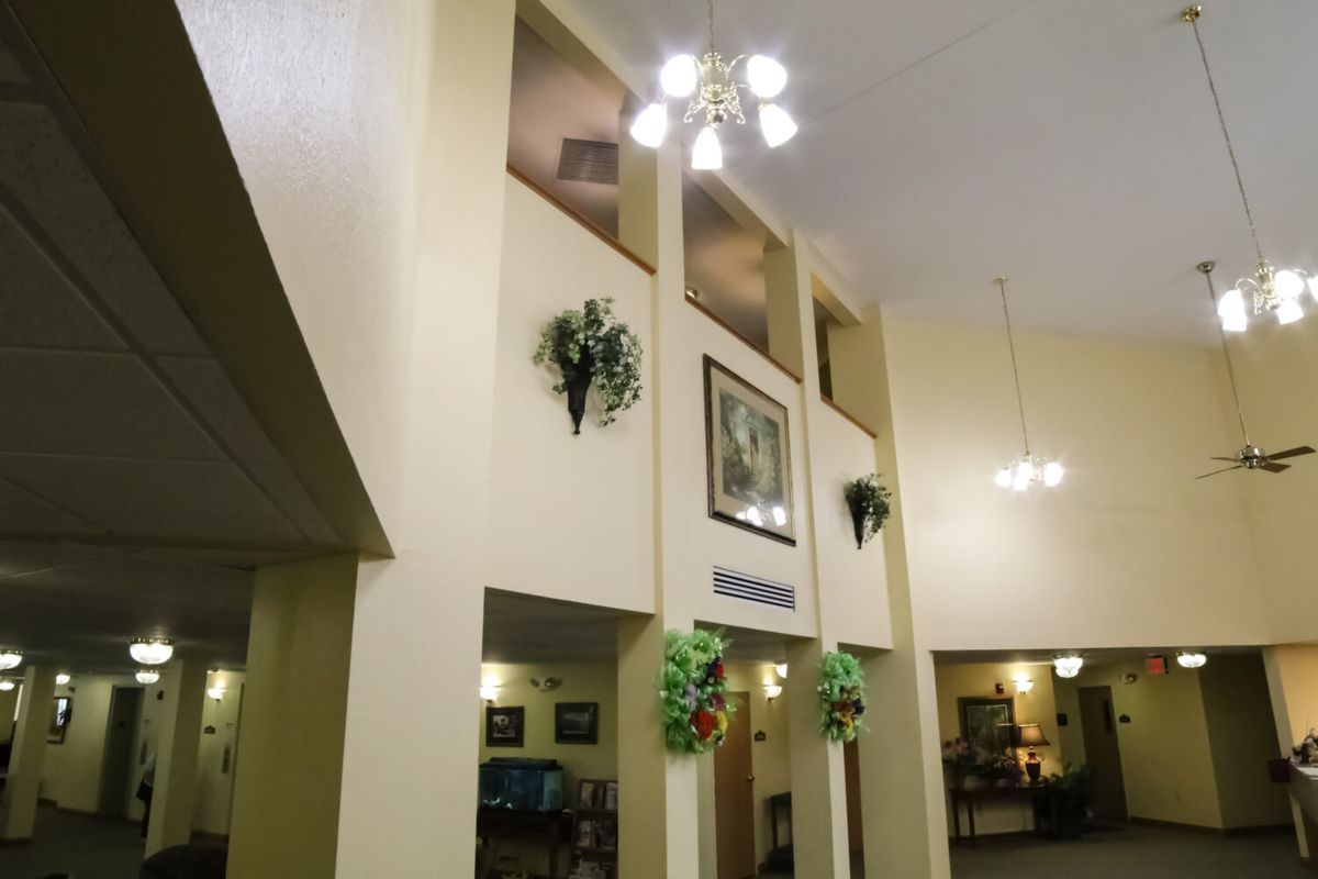 A spacious lobby with high ceilings, decorative plants, and elegant lighting.