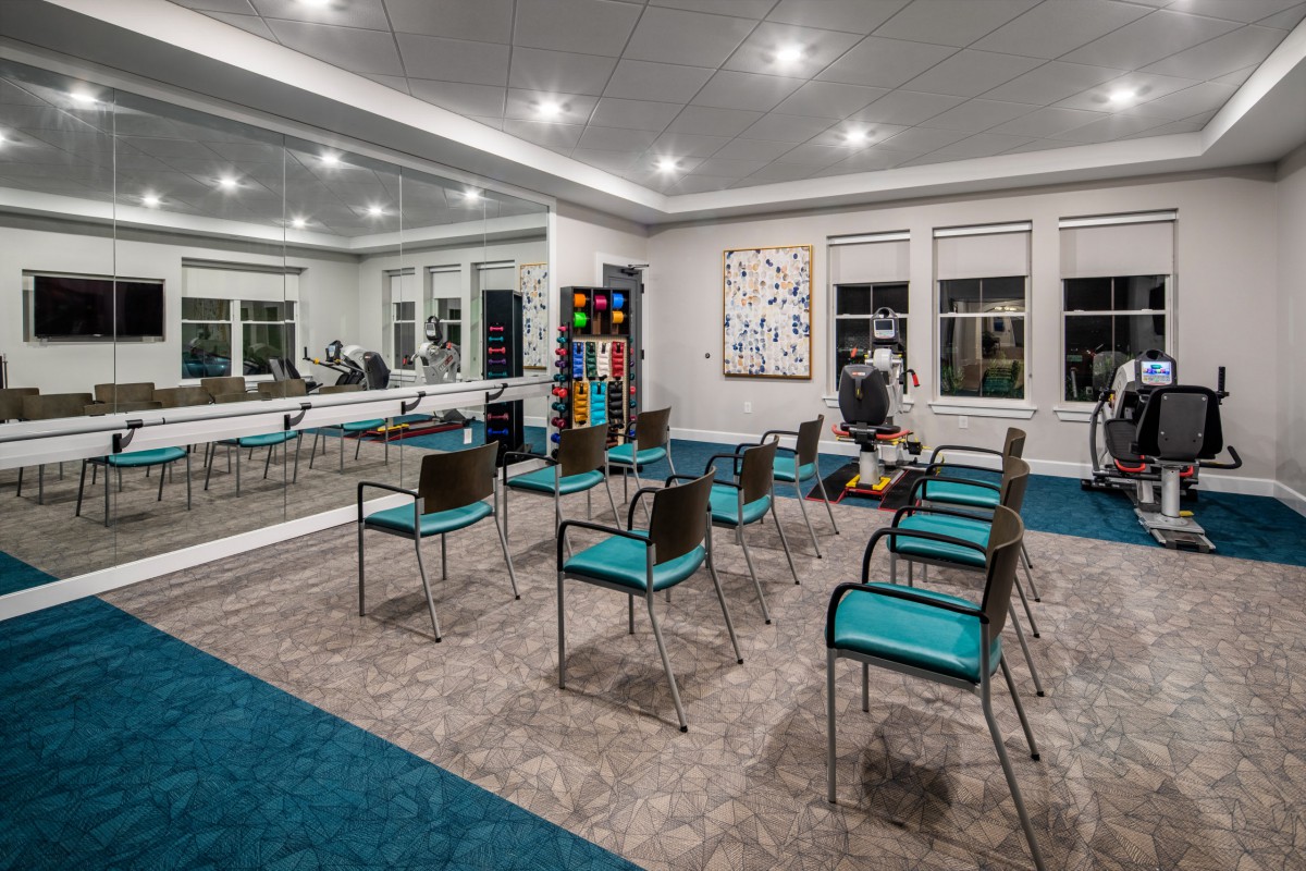 A modern conference room with teal chairs and contemporary artwork.