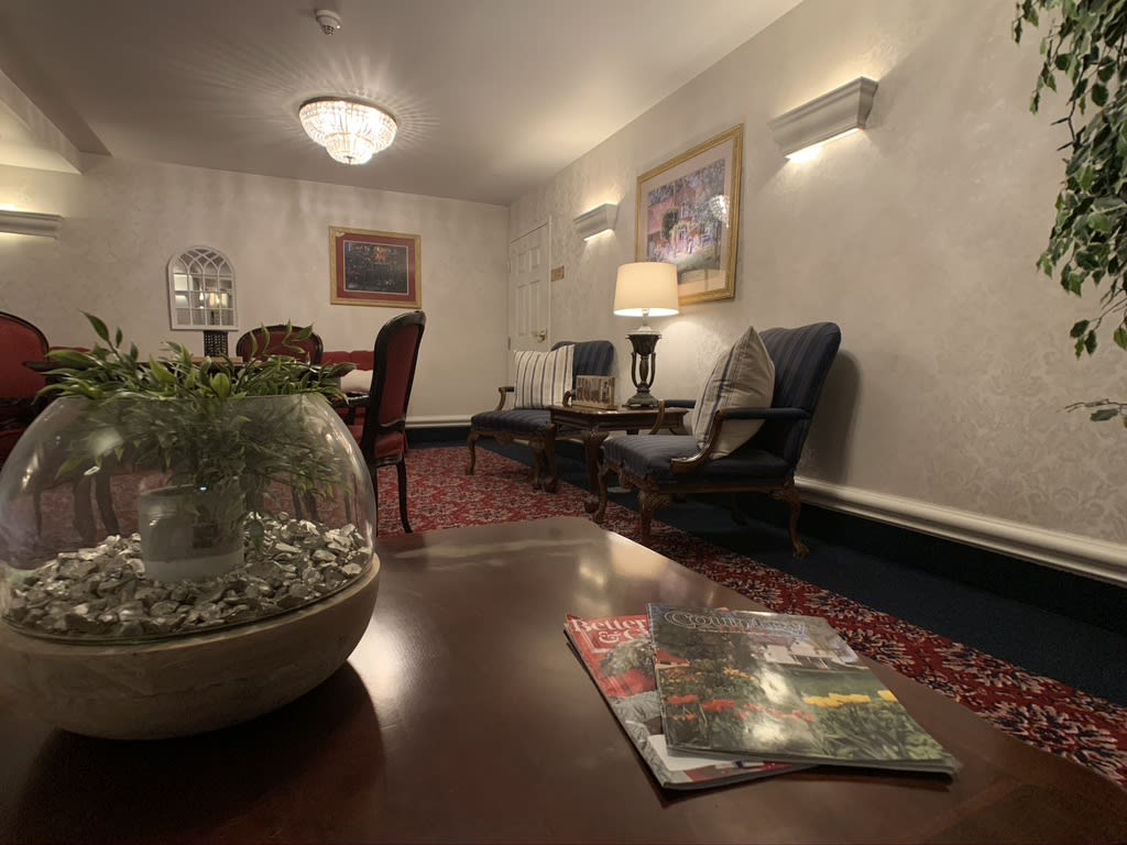A cozy lounge area featuring comfortable seating, a decorative rug, and ambient lighting.