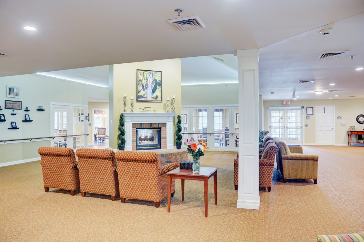 A spacious living room with comfortable seating and a central fireplace.