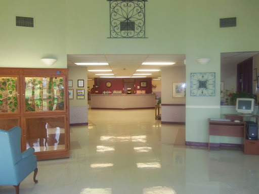 A spacious lobby with a reception area and exhibits displayed in glass cases.