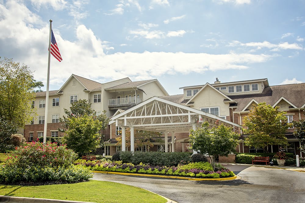 A well-maintained building with landscaped entrance and an American flag flying nearby.