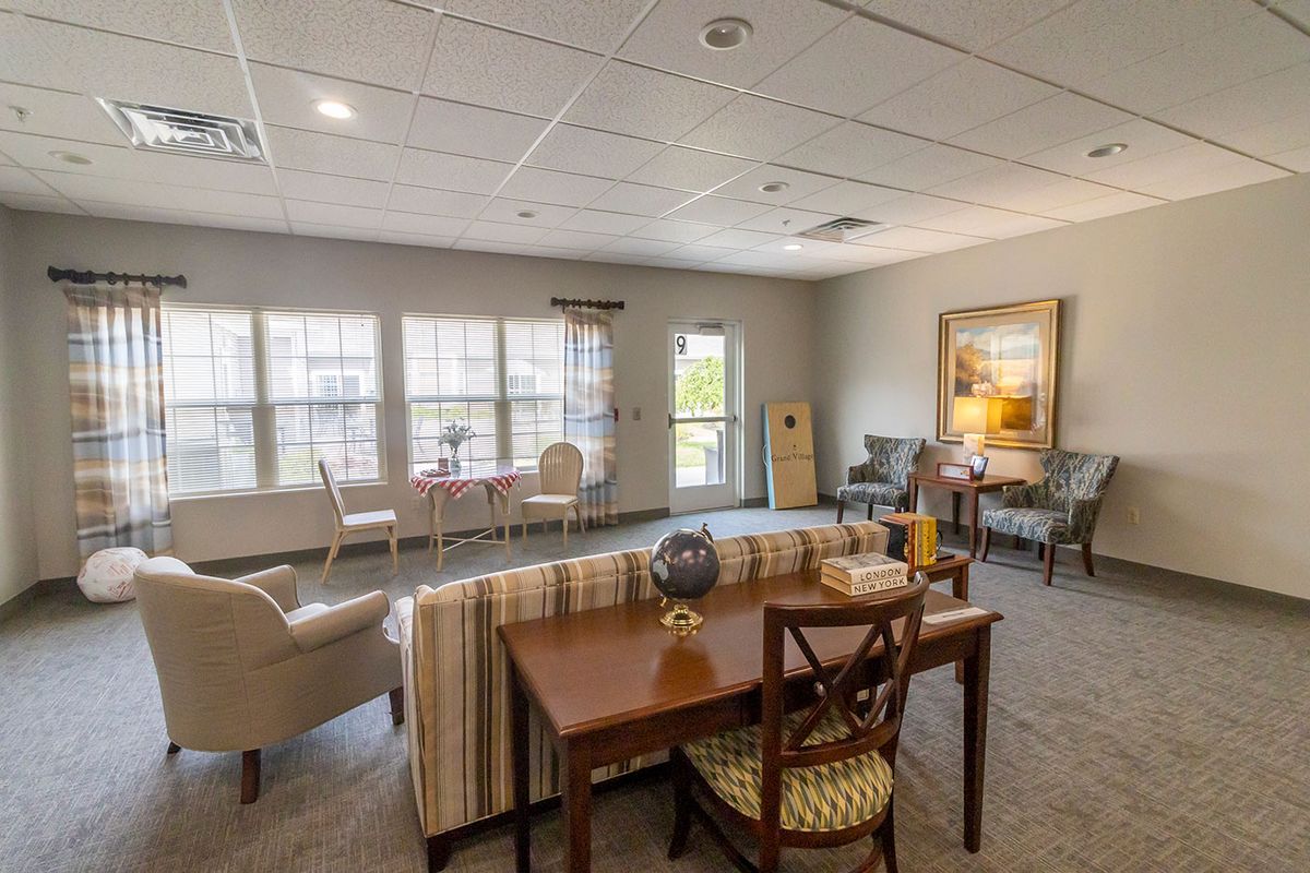 A cozy and well-lit living room with comfortable seating and large windows.