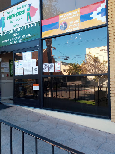 A storefront with large windows reflecting the surrounding area.