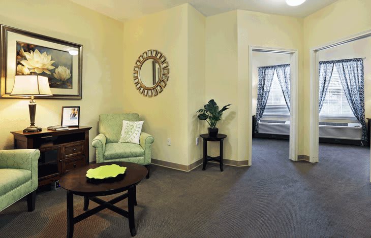 A cozy living room with a green armchair and decorative elements.