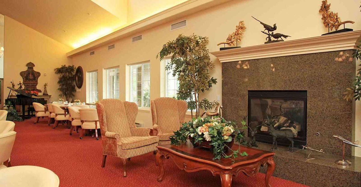 A cozy living room with elegant chairs, a decorative table, and a fireplace.