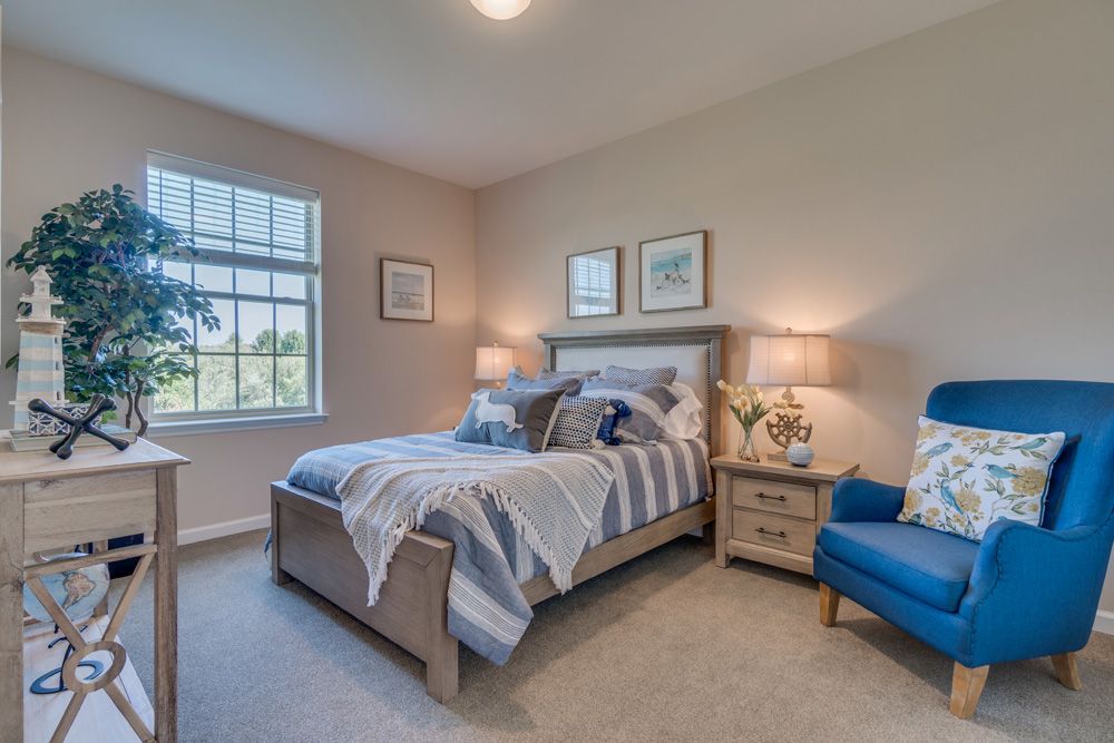 A cozy and well-decorated bedroom featuring a comfortable bed, elegant lamps, and tasteful artwork.
