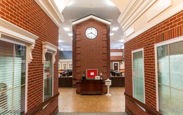 An indoor space featuring a large brick clock tower in a library setting.