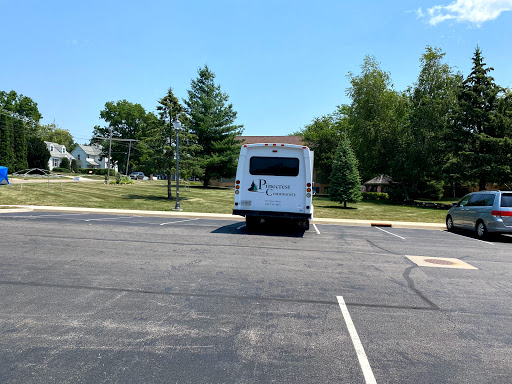 A parked bus in a spacious parking lot on a sunny day.